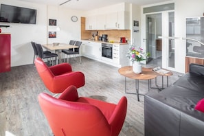 A modern living space with a dining area, kitchen, and seating arrangements. - Holiday apartment in Norderney with Wi-Fi (Norderney)