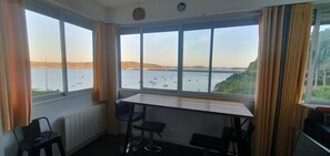 A room with a view of the sea, a table, two chairs, and a radiator. - Route du Rhum with a Sea View in Dinard (Dinard)