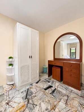 A room with a wardrobe, a vanity with a mirror, and a patterned floor. - Charming Thai Mountain Villa (MVV) (Kathu)