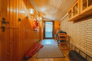 A narrow hallway with wooden walls and a tiled floor, leading to a door with a view of the outside. - Holiday home in Büsum with swimming pool (Büsum)