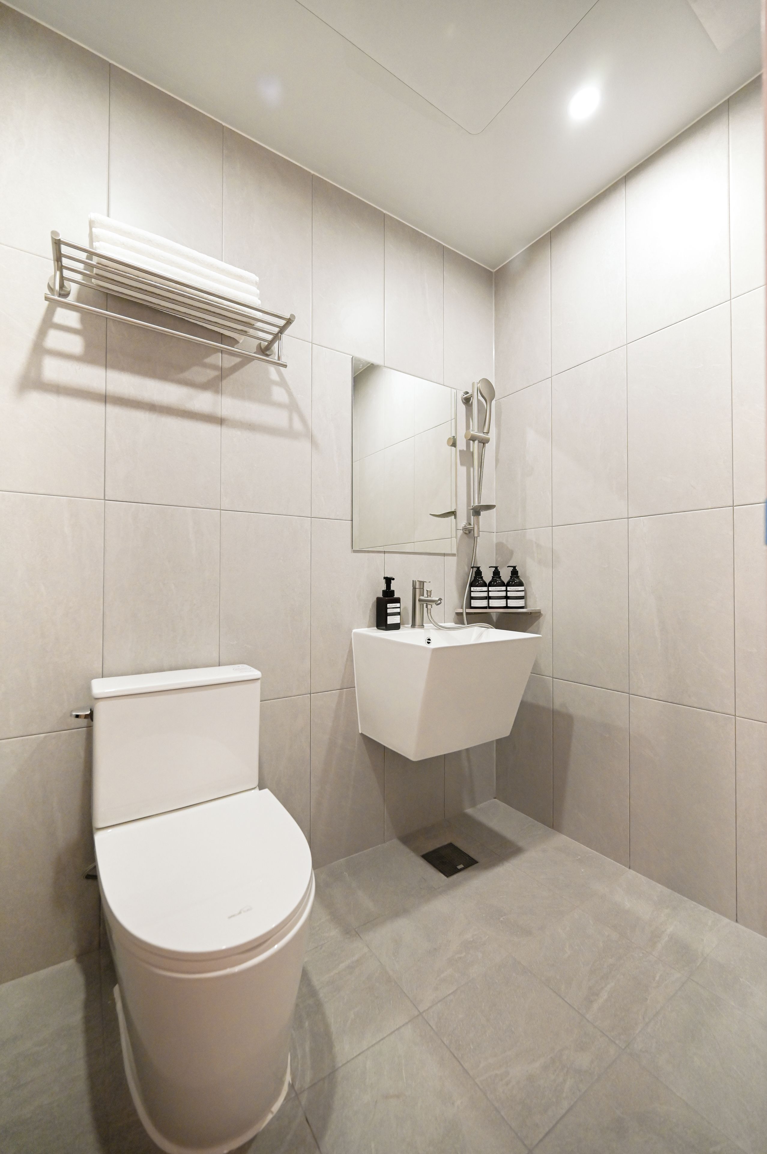 A modern bathroom with a toilet, sink, and shower.