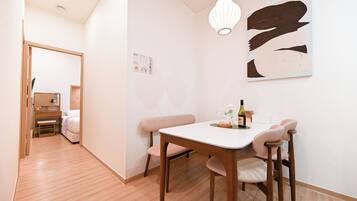 Una habitación moderna con una mesa de comedor, sillas, una lámpara colgante y una obra de arte en la pared.