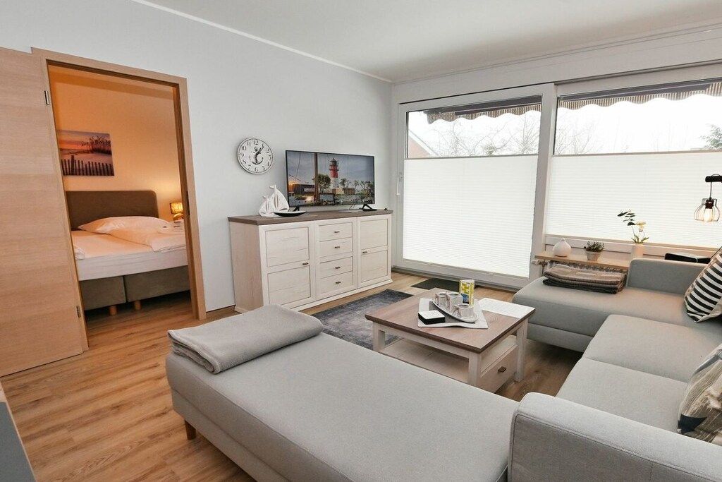 A compact living space with a bed, sofa, coffee table, and a TV.
