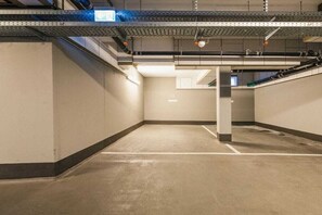 An empty parking garage with concrete floors and walls, metal beams, and visible pipes. - Logierhaus Friedrich WE 2 (Zingst (Ostseeheilbad))