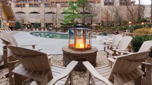 A poolside area with Adirondack chairs, a fire pit, and a pool. - Family Escape Awaits at Holiday Inn Club Vacations Smoky Mountain Resort- 2 Bd. (Gatlinburg)