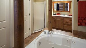Un baño con bañera, ducha y tocador con espejo.