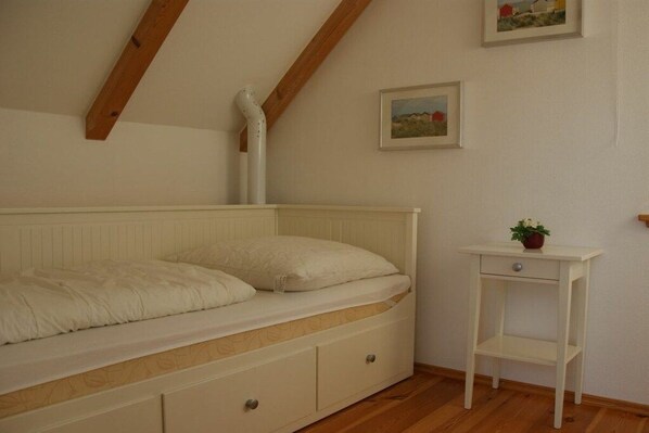 Ein Schlafzimmer mit einem Bett, einem Nachttisch und einer Heizung.