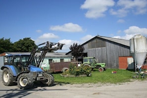 Una granja con un tractor azul, un tractor verde y un granero.
