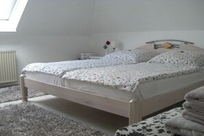 Ein Schlafzimmer mit einem Bett, einem Nachttisch, einem Heizkörper und einem Fenster.