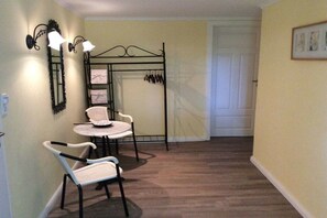 Une pièce comprenant un lit, une table de chevet, une chaise, une lampe et une étagère fixée au mur.
