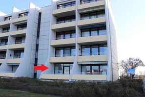 A multi-story building with balconies and a central vertical structure. - Holiday apartment with 2 bedrooms (Fehmarn)