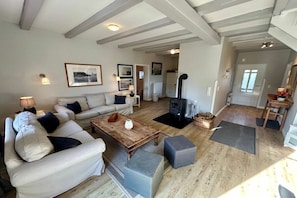 A living room with a sofa set, a coffee table, and a fireplace. - Holiday home with 3 bedrooms (Schönberger Strand)
