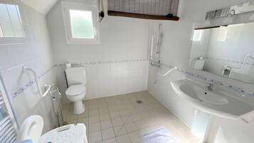 Een moderne badkamer met toilet, hygiëneschuimer en wastafel.