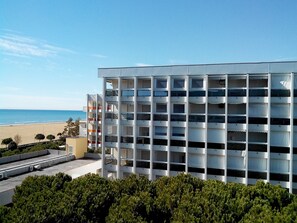 Ein Mehrstöckiges Hotel mit Balkonen mit Blick auf einen Strand.