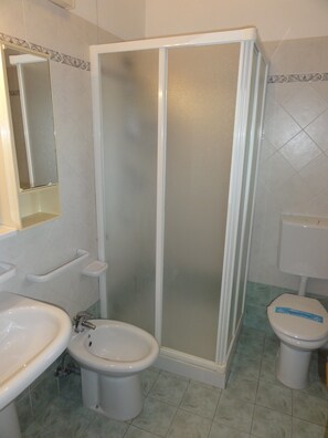 A bathroom with a shower enclosure, a bidet, a toilet, and a sink. - Peaceful village with pool (Bibione)