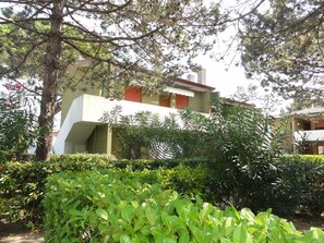 A building with a modern architectural style, featuring a flat roof and a prominent overhang. - Peaceful village with pool (Bibione)