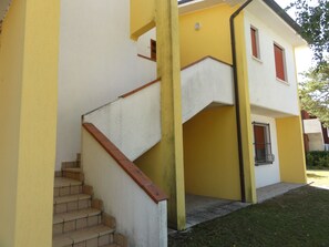 A two-story building with a staircase leading to the upper floor. - Family apartment with pool access (Bibione)