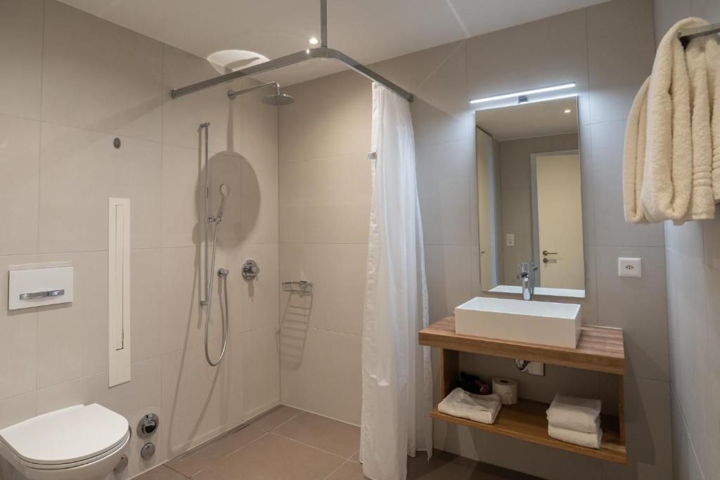 Un baño moderno con ducha, inodoro y tocador.
