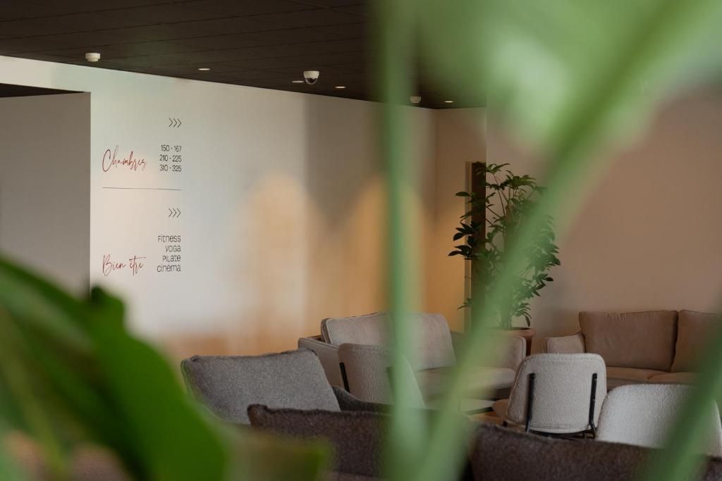 Un interior moderno con un menú adherido a la pared que enumera servicios como 'Sillas', 'Fitness', 'Yoga', 'Plato' y 'Cine'.