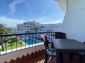 A balcony with a view of a swimming pool and a building complex. - Apartment in Nerja Near Playa El Salon (Nerja)