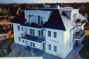 A large, white building with multiple balconies and a prominent name on the side. - Holiday apartment with 2 bedrooms (Börgerende)