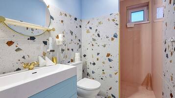 Ein Badezimmer mit einem weißen Waschbecken, einem goldenen Wasserhahn und einem blauen Schrank.