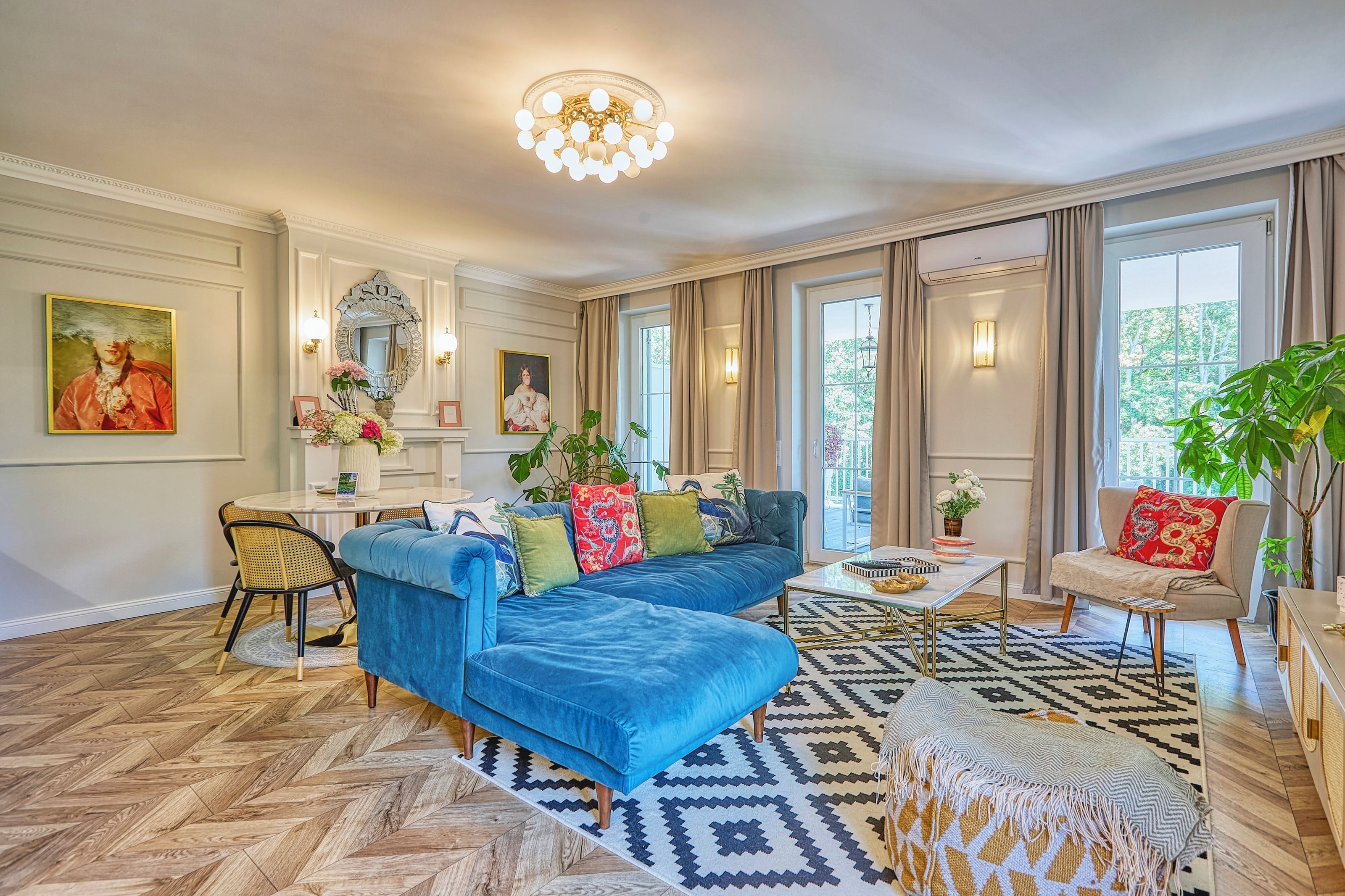 A spacious living room with a blue sofa, a coffee table, and a patterned rug.