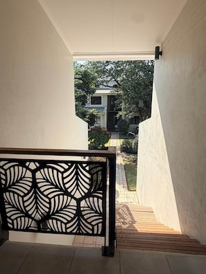 A staircase leading to a residential area with a view of a house and garden.