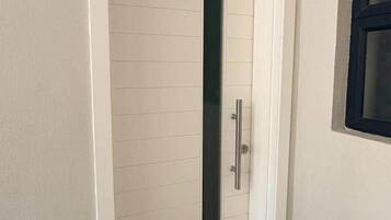 A white door with a vertical handle and a glass panel.