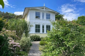A two-story building with a garden pathway leading to the entrance. - Fischerweg - Villa Angelika (Seebad Bansin)