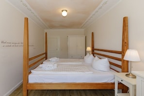 A hotel room with a wooden bed, a bedside table with a lamp, and a wall with a decorative quote. - Holiday apartment holiday dreams by the sea 319538 (Kühlungsborn)