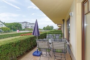 A balcony with outdoor furniture, a covered area, and a view of the surrounding landscape. - Holiday apartment holiday dreams by the sea 319538 (Kühlungsborn)