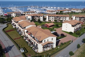 A coastal residential area with multiple apartment buildings, a marina with boats, and a road. - Holiday apartment holiday dreams by the sea 319538 (Kühlungsborn)