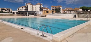 Ein Swimmingpool mit glatter, blauer Wasseroberfläche, umgeben von einer Betonplattform.
