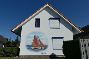A house with a mural of a sailboat on the side. - Holiday home with 1 bedroom (Poel \/ OT Kaltenhof)