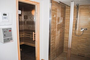A sauna with a wooden interior and a glass-enclosed shower area with a tiled floor. - 8 in the Capitello Residence (Ostseebad Binz)