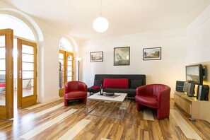 A living room with a sofa, two armchairs, a coffee table, and a television. - Holiday apartment in Binz with swimming pool (Binz)