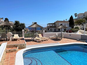 A rooftop pool area with lounge chairs and a view of the sea. - Villa in Nerja Near Burriana Beach (Nerja)
