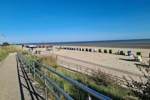 A beach with a paved walkway, a row of beach chairs, and a clear sky. - Holiday home with 2 bedrooms (Wyk auf Föhr)