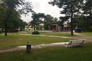 A park with a stage, benches, and a trash can. - Holiday apartment with 1 bedroom (Ostseebad Baabe)