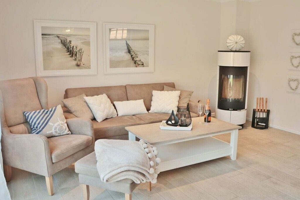 A living room with a sofa, armchair, coffee table, fireplace, and wall art.