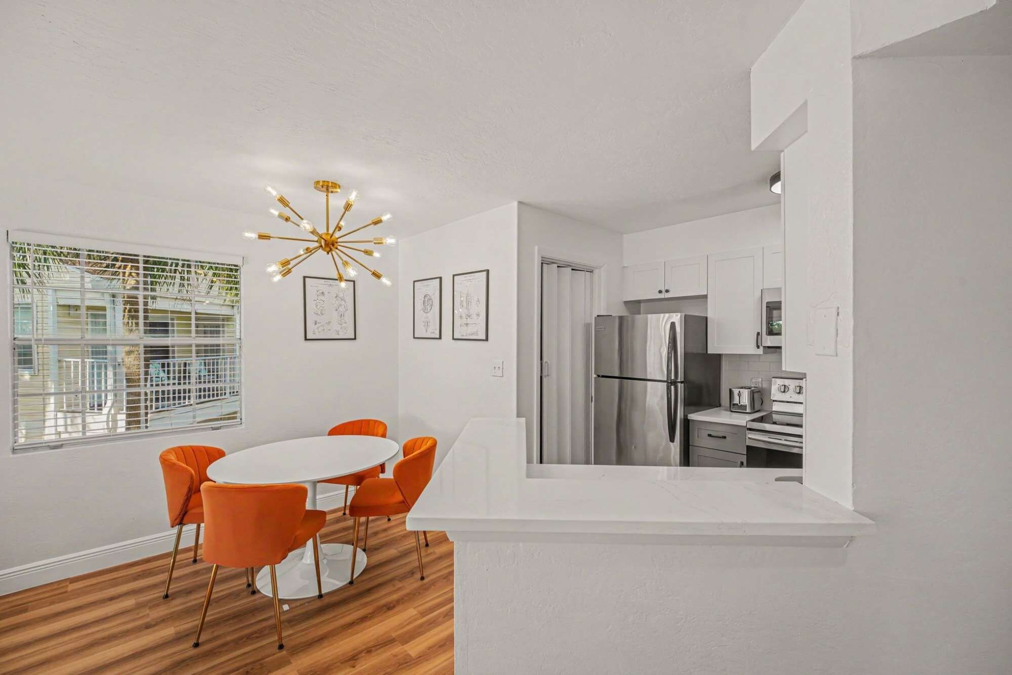 A modern kitchen with a stainless steel refrigerator, white cabinets, and a built-in oven.