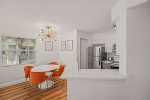 A modern kitchen with a stainless steel refrigerator, white cabinets, and a built-in oven. - Space Age King Bed Condo · Half Mile to Beach (Melbourne)