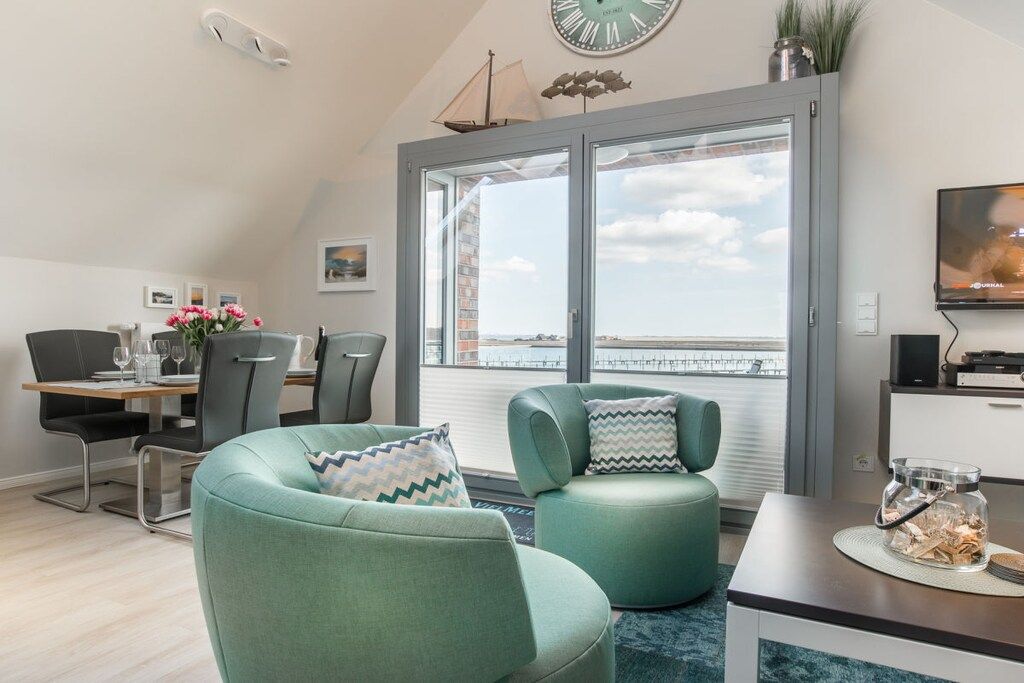 Een moderne woonkamer met een eethoek, grote ramen en uitzicht op de stad.