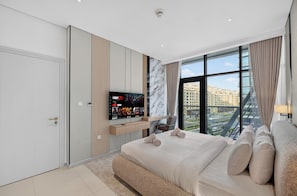 A modern hotel room with a large bed, a mounted TV, and a city view. - Seven Palm | 1BR, Sweet, Stylish & Serene (Dubai)