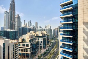 A modern urban skyline with high-rise buildings, including a distinctive tower with a unique design. - Trillionaire | 1BR, Trendy, Timeless & Tempting (Dubai)