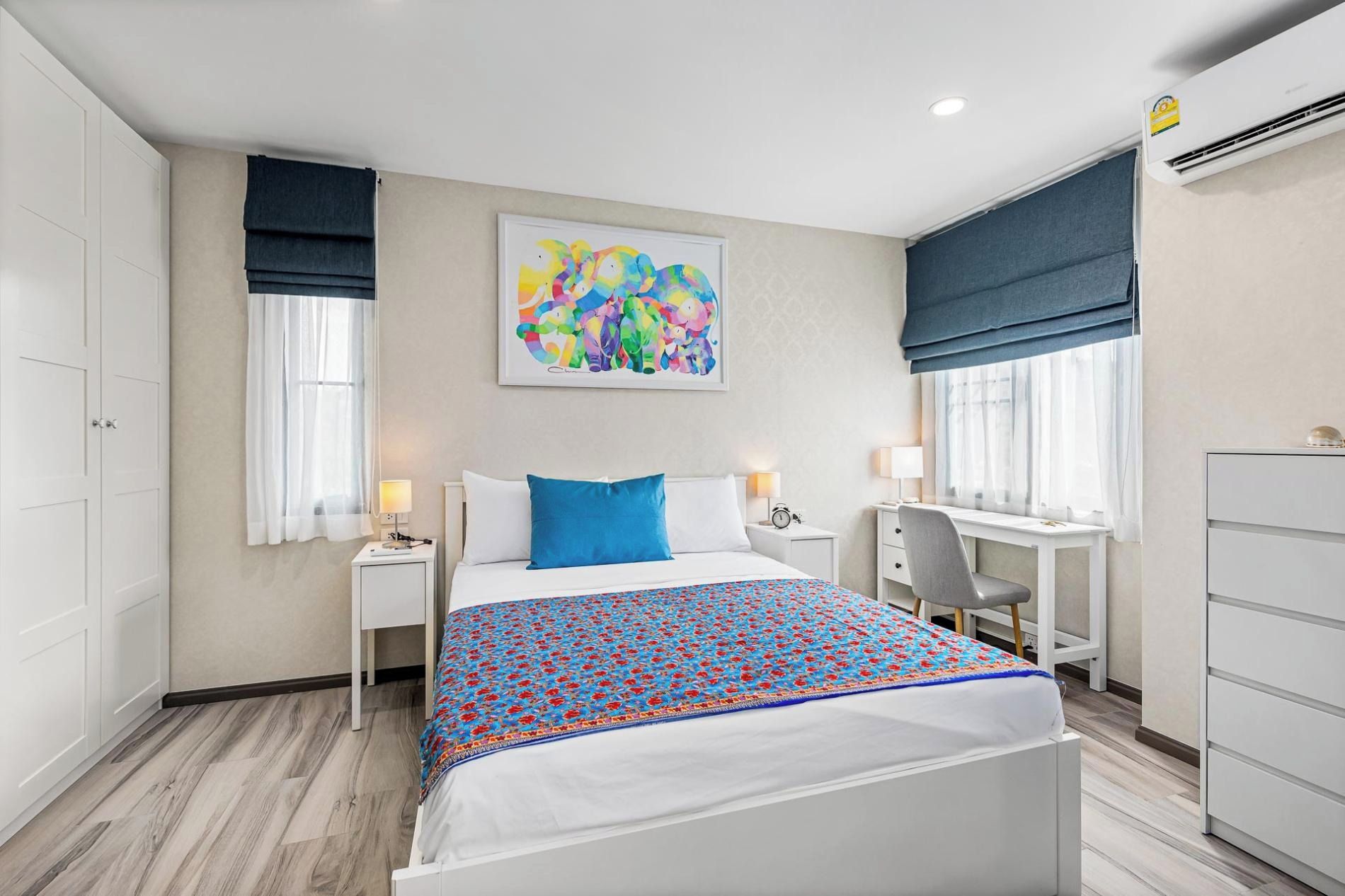 Une chambre d’hôtel comprenant un lit, des tables de chevet, un bureau et une armoire.