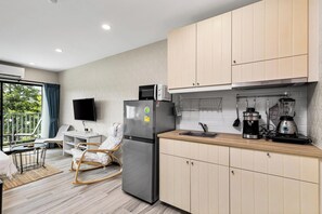 A modern kitchen with a refrigerator, microwave, coffee maker, and blender. - Bright Corner 1 Bed Retreat (TC-F306) (Thalang)