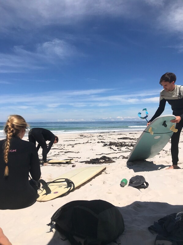A beach scene with surfers preparing their equipment.