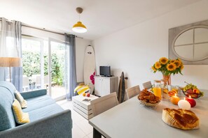 Ein modernes Wohnzimmer mit einer Couch, einem Esstisch und einem Surfbrett.